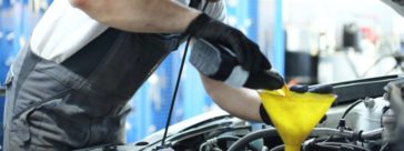 Mechanic topping up engine oil